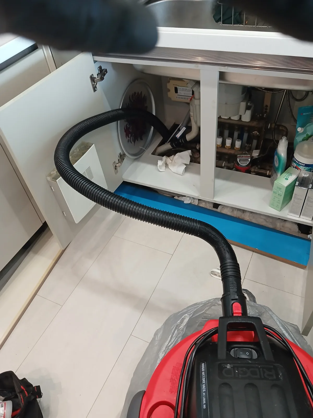 파주시 동패동 싱크대막힘 싱크대 하부 배관에 석션 호스를 연결해 물과 기름 찌꺼기를 흡입하는 작업 모습.
